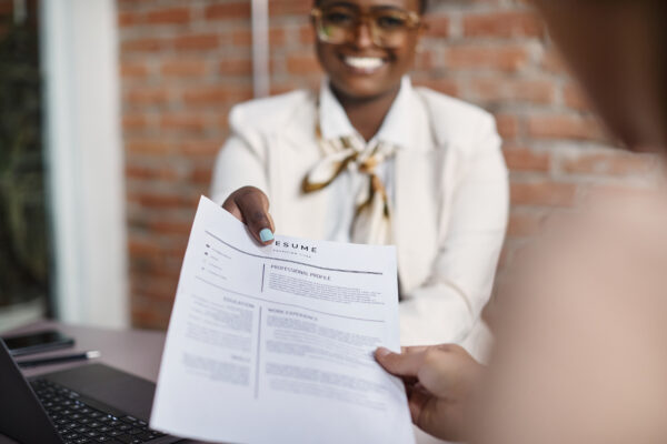 A person handing a resume to another person.