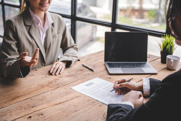 Two people sitting at a table reviewing a resume.